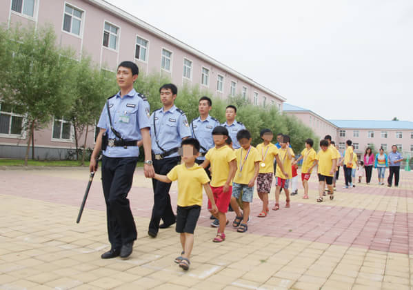 监狱警官带着儿童村的孩子进入七监区的帮教活动大厅