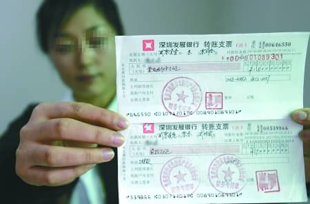 "民工代表李素梅向记者出示了两张转账支票:一张金额70万元,出票日期
